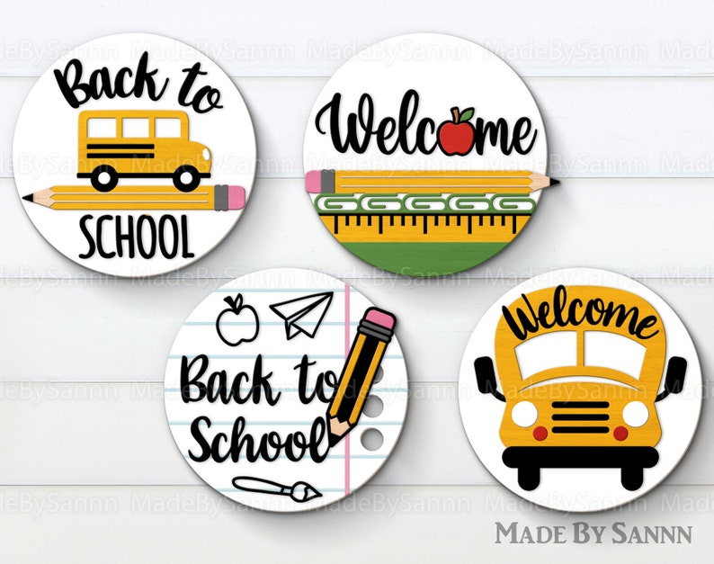 May include: Four round, white, paper, back to school themed, circle stickers. The stickers feature a yellow school bus, pencils, a ruler, an apple, a paper airplane, and the words "Back to School" and "Welcome".