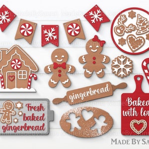 Puede incluir: Un conjunto de 12 recortes de madera con temática de pan de jengibre, que incluyen una casa de pan de jengibre, hombres de pan de jengibre, bastones de caramelo, copos de nieve y un rodillo. Los recortes están pintados en tonos de marrón, rojo y blanco. El texto "Pan de jengibre recién horneado" y "Horneado con amor" se incluye en dos de los recortes.