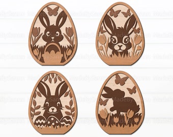 May include: Four laser cut wooden Easter egg designs featuring a bunny rabbit in a variety of poses. The eggs are decorated with flowers, butterflies, and grass.