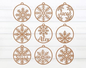 May include: Nine wooden Christmas baubles with snowflake designs. Each bauble has a space for a name, with the names "Jacob", "Alex", and "Stella" visible.