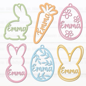 Könnte beinhalten: Sechs pastellfarbene Ostereier-Ausschnitte mit dem Namen "Emma" auf jedem. Die Ausschnitte sind in Form eines Hasen, einer Karotte, eines Eies mit Blumen, eines Eies mit Blättern und zwei weiteren Hasen.