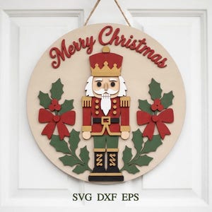 May include: A circular wooden sign featuring a nutcracker figure in a red, gold, and black uniform, flanked by green holly leaves and red bows. The text Merry Christmas is written in red script at the top. The sign includes the text SVG DXF EPS.