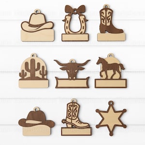 May include: Wooden cowboy-themed ornaments in various shapes, including a cowboy hat, horseshoe, cowboy boot, cactus, bull head, horse, and sheriff's star. Each ornament has a light brown base and a darker brown design.