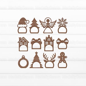 K&ouml;nnte beinhalten: Set mit 12 Weihnachts-Serviettenringen aus Holz mit verschiedenen Designs, darunter ein Weihnachtsbaum, ein Schneemann, ein Haus, eine Geschenkbox, eine Schneeflocke, ein Engel, ein Rentier, ein Lebkuchenmann und ein Ornament.