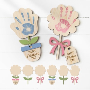 Könnte beinhalten: Holzblumenförmige Bastelarbeiten mit Handabdruck-Designs in Blau und Rosa. Die Bastelarbeiten umfassen grüne Blätter, blaue und rosa Schleifen und den Text "Happy Mother's Day". Zusätzliche blumenförmige Bastelarbeiten sind ebenfalls enthalten.