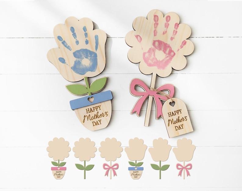 May include: Wooden flower-shaped crafts with handprint designs in blue and pink. The crafts include green leaves, blue and pink bows, and the text "Happy Mother's Day". Additional flower-shaped crafts are also included.