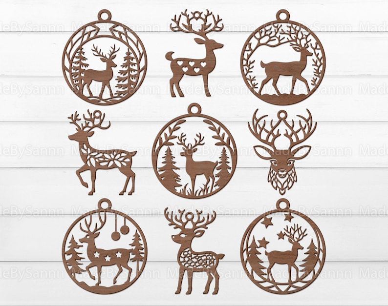 May include: Nine laser cut wooden ornaments featuring a deer design. The ornaments are round and have a hole at the top for hanging. Some of the ornaments have a more intricate design with leaves and branches, while others have a simpler design with just the deer.