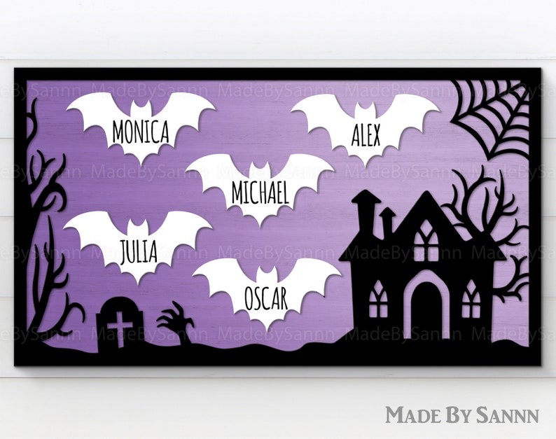 May include: A purple and black Halloween-themed sign with a black silhouette of a house and bats. The bats have white names on them: Monica, Alex, Michael, Julia, and Oscar.