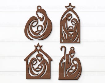 May include: Four wooden Christmas ornaments depicting the Nativity scene. Each ornament is a different shape, including a circle, a star-topped arch, a house, and a silhouette of a shepherd. The ornaments are cut from brown wood and have a hole for hanging.