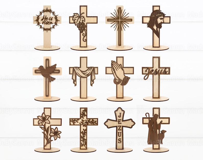 May include: A collection of twelve wooden crosses with various designs. Some crosses feature a crown of thorns, grapes, a dove, praying hands, and the word "Jesus." Each cross is mounted on a circular base, showcasing a natural wood grain.