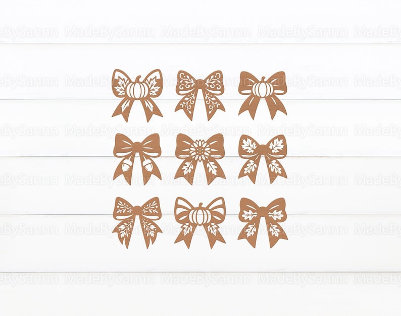 May include: Nine brown decorative bows with various fall-themed designs, including pumpkins, acorns, and leaves. The bows are arranged in three rows of three on a white wooden background. The bows are cut from a solid material.