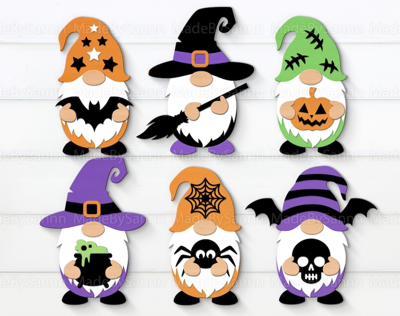 Może przedstawiać: Sześć krasnoludk&oacute;w halloweenowych z r&oacute;żnymi motywami. Krasnoludki są pomarańczowe, zielone, fioletowe i czarne z białymi akcentami. Noszą czapki i trzymają r&oacute;żne przedmioty halloweenowe, takie jak nietoperz, miotła, dynia, pająk, kocioł i czaszka.