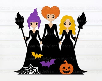 May include: Three witches with black dresses, purple, orange, and blonde hair, holding brooms with black handles and orange tips. The witches are standing in front of a white wood background with a spiderweb, bats, and a jack-o-lantern.