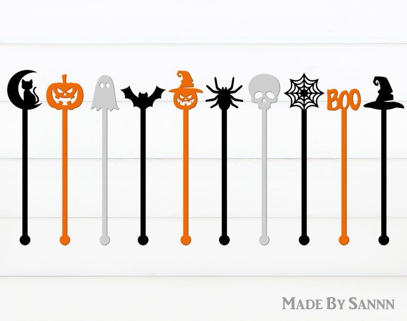 May include: Set of ten Halloween-themed stir sticks. The sticks are black, orange, and gray and feature various Halloween icons, including a ghost, a bat, a pumpkin, a spider, a skull, a witch's hat, and a spiderweb. The sticks are all approximately 10 inches long.