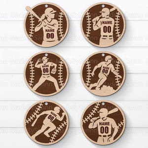 Peut inclure: Six ornements en bois sur le thème du baseball. Chaque ornement présente une silhouette de joueur de baseball à l'intérieur d'une forme de baseball. Le maillot du joueur porte le numéro "00" et un espace pour un nom. Les ornements sont marron clair avec des accents marron foncé.