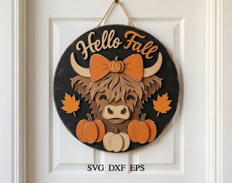 May include: A circular wooden wall sign with a black background featuring a layered cutout of a brown Highland cow wearing an orange bow. The text Hello Fall is at the top, with orange maple leaves and three pumpkins below. It hangs by a rope.