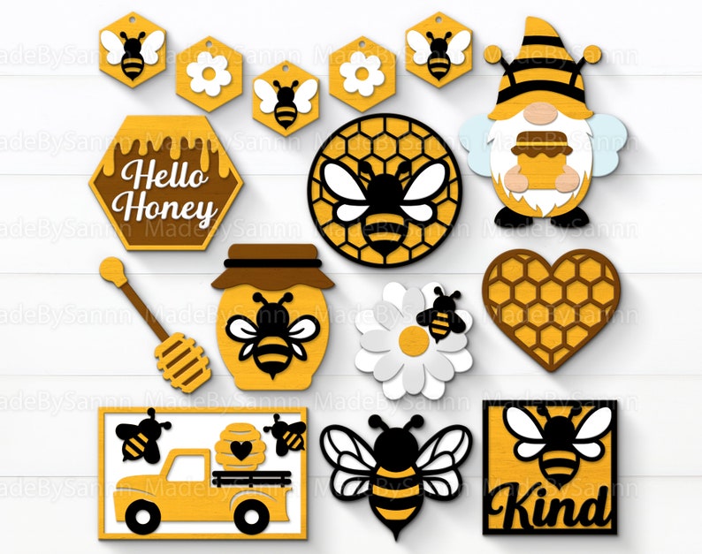 May include: A set of 11 laser cut wooden honeybee themed decorations. The decorations include a beehive, a bee, a honey pot, a truck, a gnome, a heart, a daisy, a sign that says "Hello Honey", and a sign that says "Kind".