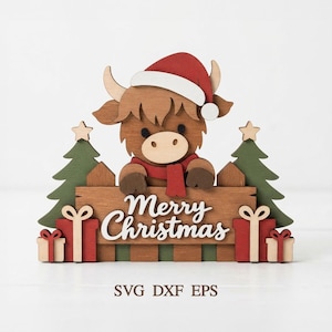 Peut inclure: Une décoration en bois découpé en couches représentant une vache highland brune portant un bonnet et une écharpe de Père Noël rouge, placée derrière une clôture avec le texte Merry Christmas, flanquée de deux sapins verts et quatre cadeaux.