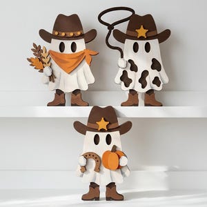 May include: Three wooden ghost figures dressed as cowboys, each wearing a brown hat. One ghost holds wheat and wears an orange bandana, another holds a lasso and has cow print spots, and the third holds a horseshoe and an orange pumpkin.