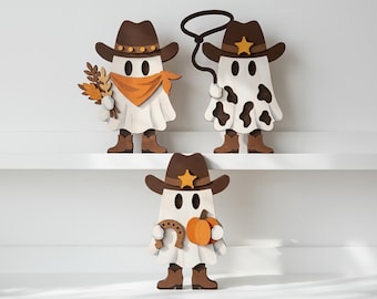 May include: Three wooden ghost figures dressed as cowboys, each wearing a brown hat. One ghost holds wheat and wears an orange bandana, another holds a lasso and has cow print spots, and the third holds a horseshoe and an orange pumpkin.