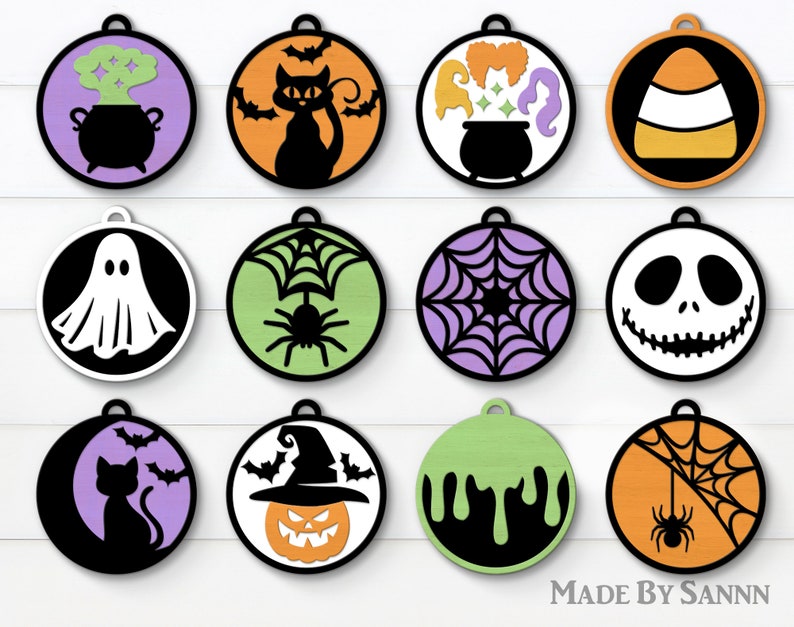 Puede incluir: Doce adornos redondos con tem&aacute;tica de Halloween con varios dise&ntilde;os, que incluyen un fantasma, una ara&ntilde;a, un sombrero de bruja y ma&iacute;z dulce. Los adornos son todos en blanco y negro con acentos de colores.