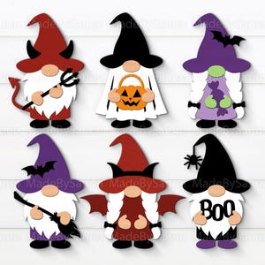 May include: Six Halloween-themed gnome cutouts. Each gnome has a different costume, including a devil, ghost, witch, and vampire. The gnomes are in various colors, including red, black, purple, and orange. One gnome has the word "BOO" on its beard.