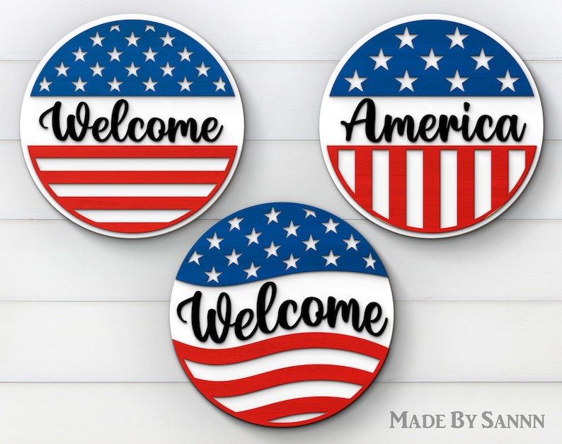 May include: Three round wooden signs with a red, white, and blue American flag design. The top sign says "America", the middle sign says "Welcome", and the bottom sign says "Welcome".