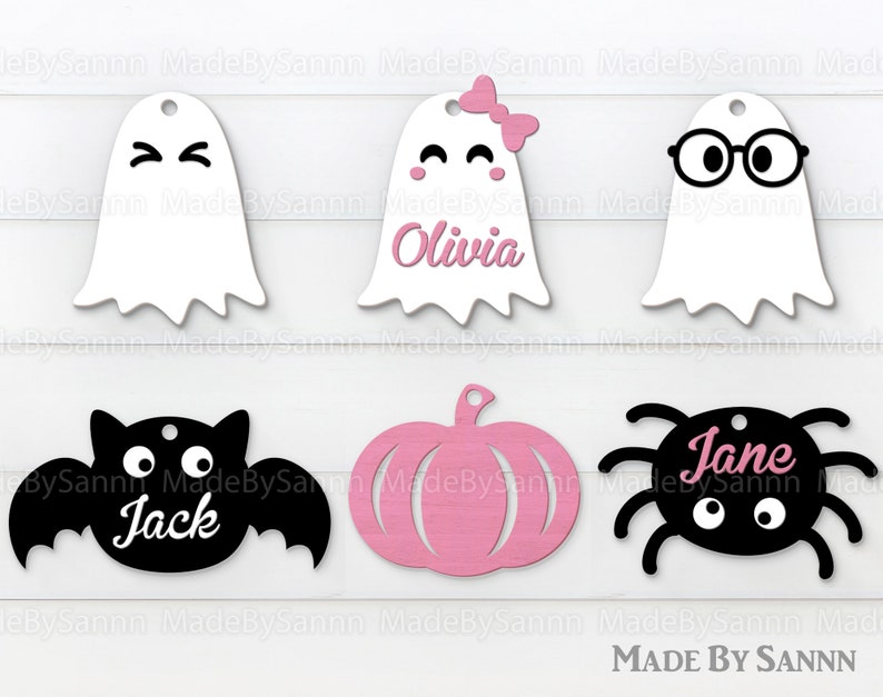 May include: Six Halloween-themed gift tags with different designs. The tags are white, black, and pink. The designs include a ghost, a pumpkin, a bat, a spider, and two ghosts with different facial expressions. The tags are labeled with the names "Olivia", "Jane", and "Jack".