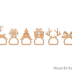 May include: Six wooden Christmas napkin rings in various festive designs. The set includes a reindeer, snowflake, Christmas tree, gift, antlers, and a bow. Each ring has a circular base with a cutout. The items are made of light brown wood.