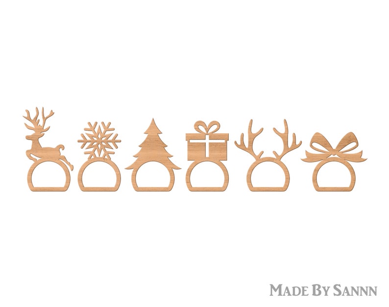 May include: Six wooden Christmas napkin rings in various festive designs. The set includes a reindeer, snowflake, Christmas tree, gift, antlers, and a bow. Each ring has a circular base with a cutout. The items are made of light brown wood.