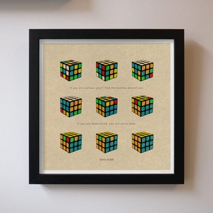 May include: A motivational quote by Erno Rubik, the inventor of the Rubik's Cube, printed on a beige background. The quote reads, "If you are curious, you'll find the puzzles around you. If you are determined, you will solve them." The quote is surrounded by nine illustrations of Rubik's Cubes in various stages of completion.