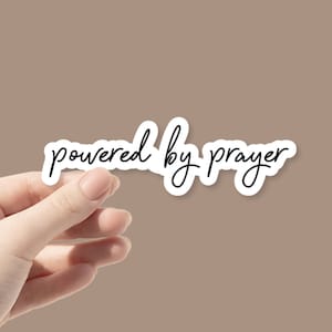 May include: White sticker with black cursive text that reads "powered by prayer".