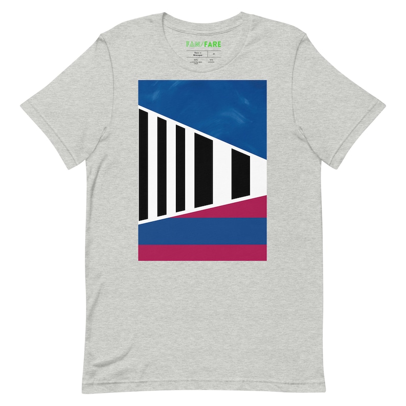 May include: A grey t-shirt with a graphic design featuring a blue, white, and burgundy geometric pattern. The design is centered on the shirt and features a series of vertical black stripes.