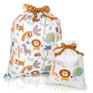 May include: Two white canvas drawstring bags with a jungle animal print. The larger bag has a variety of animals including a lion, giraffe, zebra, and elephant. The smaller bag has a lion, giraffe, and elephant and the text "WILD ONE".