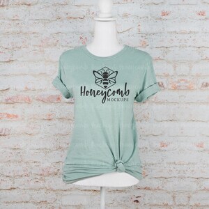 May include: A sage green t-shirt mockup with a black honeycomb and bee logo that says "Honeycomb Mockups".