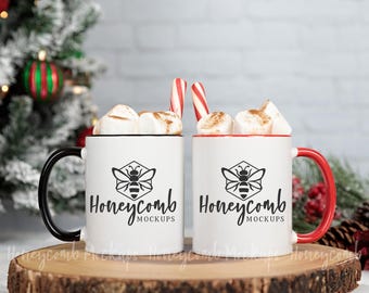 May include: Two white ceramic mugs filled with marshmallows and candy canes. Each mug features a black graphic of a bee inside a hexagon above the text Honeycomb MOCKUPS. One mug has a black handle and rim, while the other has a red handle and rim.
