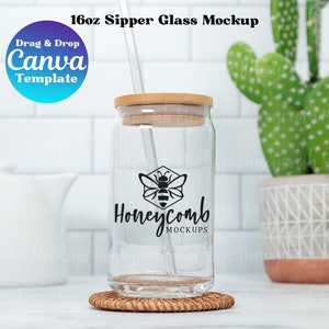 May include: Clear glass sipper glass mockup with a bamboo lid and straw. The glass features a black honeycomb logo with the text "Honeycomb Mockups". The glass sits on a small woven coaster. The text "16oz Sipper Glass Mockup" is at the top.