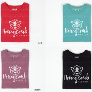 May include: Four folded t-shirts in different colors: red, berry, seafoam, and black. Each shirt features a white honeycomb logo with a bee inside and the text "Honeycomb Mockups".