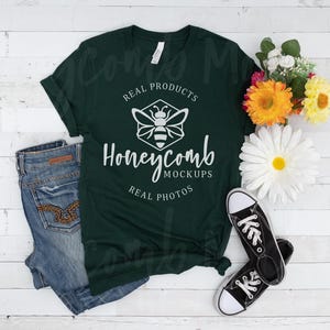 May include: A dark green t-shirt with a white honeycomb design and the text "Real Products, Honeycomb Mockups, Real Photos". The shirt is laid flat on a white wooden surface with a pair of black sneakers and a bouquet of flowers.