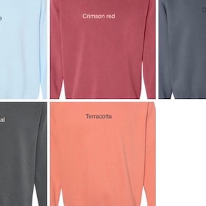 Puede incluir: Nueve sudaderas de manga larga en varios colores, incluyendo verde, azul claro, rojo carmes&iacute;, gris, morado claro, carb&oacute;n, terracota y azul marino. Cada sudadera tiene una peque&ntilde;a etiqueta de texto bordada en la parte delantera.