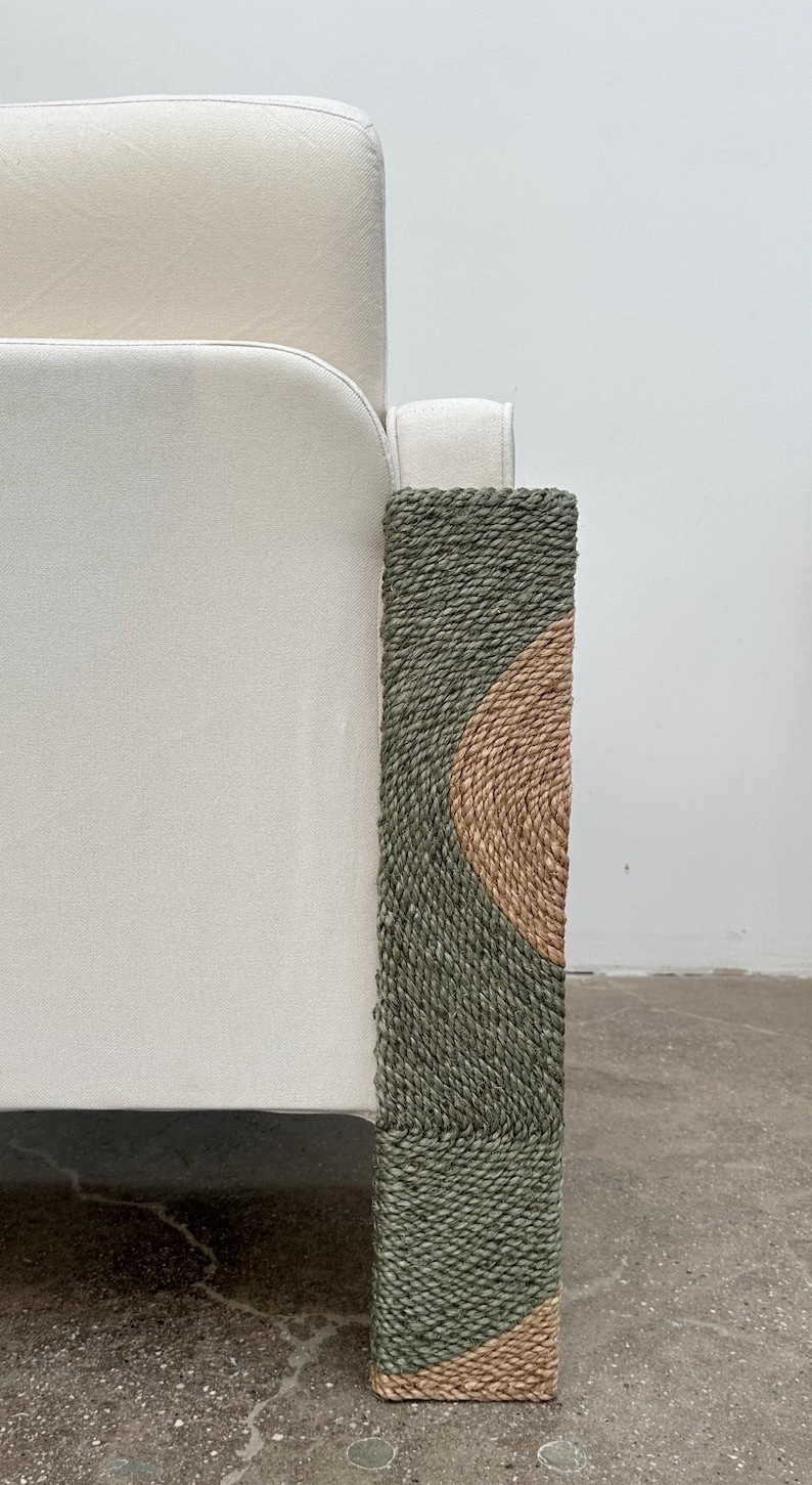 Pode incluir: Um sof&aacute; branco com uma perna de tecido tecido verde e castanho.