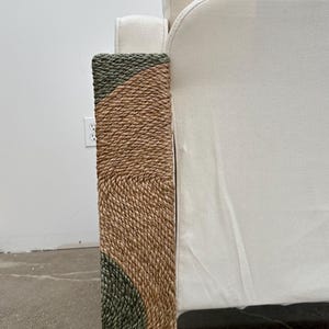 Pode incluir: Uma poltrona de tecido branco com uma base de corda tran&ccedil;ada. A corda &eacute; uma mistura de cores castanho natural e verde.