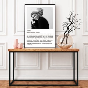 May include: Black and white photo of two women hugging. The photo is framed and has a definition of the word "Mama" in German below the photo.