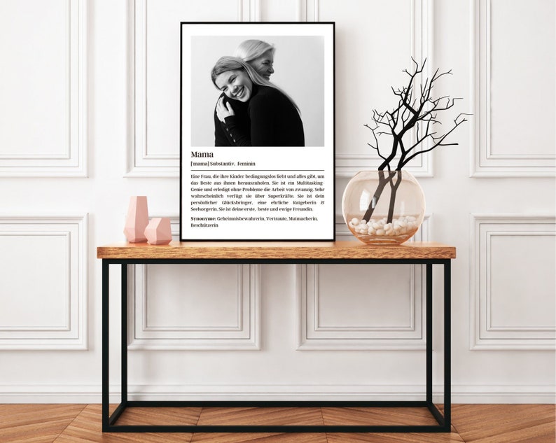 May include: Black and white photo of two women hugging. The photo is framed and has a definition of the word "Mama" in German below the photo.