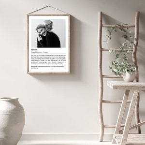 May include: Black and white photo of two women hugging. The photo is framed in a light wood frame and has a white background. The text below the photo reads "Mama" and includes a definition of the word.