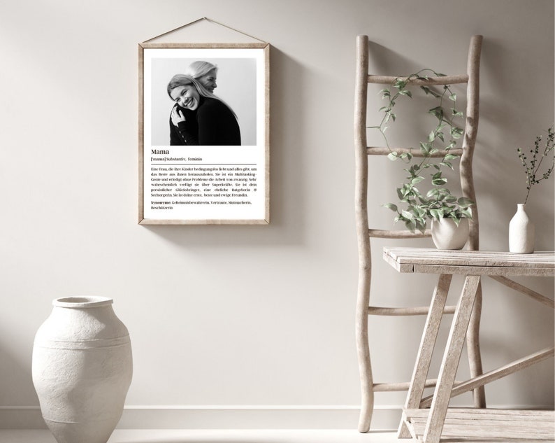 May include: Black and white photo of two women hugging. The photo is framed in a light wood frame and has a white background. The text below the photo reads "Mama" and includes a definition of the word.