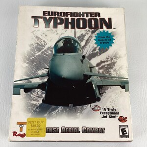 May include: A computer game box for "Eurofighter Typhoon" featuring a fighter jet over a mountain range. The box includes text such as "Defense Aerial Combat" and "From the makers of EF2000". A "Best Buy" sticker is visible.