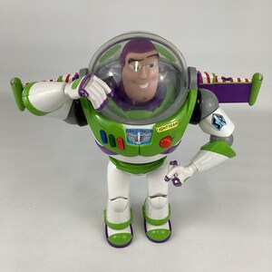 May include: A Buzz Lightyear action figure. The toy has a green and white spacesuit with purple accents. The figure has a clear helmet, a smiling face, and the words "SPACE RANGER" and "LIGHTYEAR" printed on the chest.