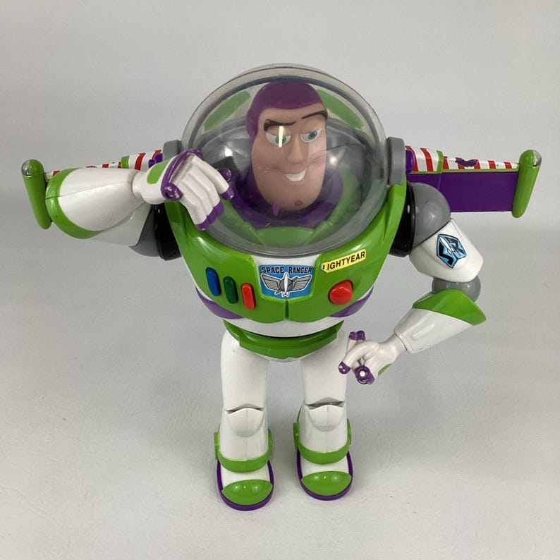 May include: A Buzz Lightyear action figure. The toy has a green and white spacesuit with purple accents. The figure has a clear helmet, a smiling face, and the words "SPACE RANGER" and "LIGHTYEAR" printed on the chest.
