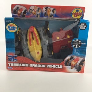 May include: A red and yellow remote control tumbling dragon vehicle with real working lights. The package shows the vehicle in different positions and includes the text "Kids Stuff" and "Tumbling Dragon Vehicle".